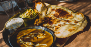 Image of a curry with a naan bread and rice