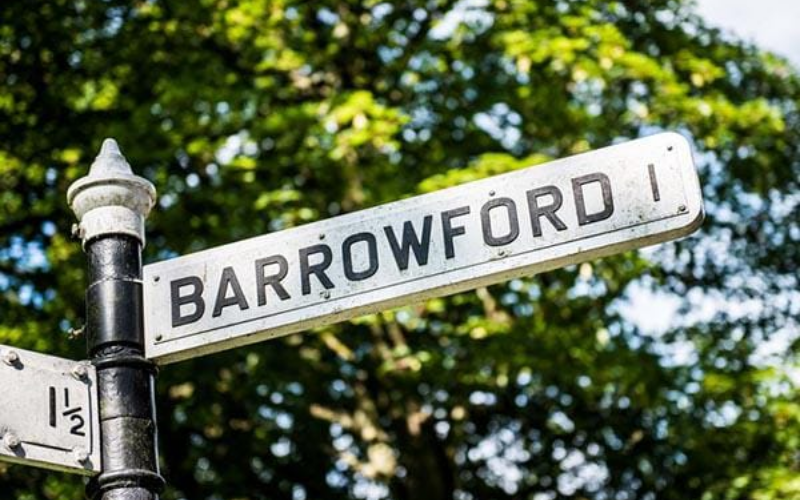 Sign post with the word "Barrowford" and a tree in the background
